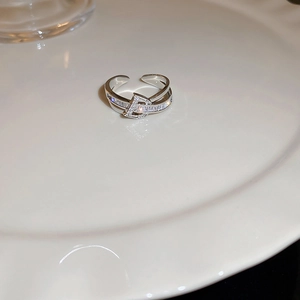 Macro shot of silver-toned double-layered ring with zircon stones and letter D charm