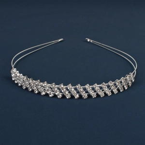 Sparkling silver bridal crown headband with clear rhinestones on a dark blue background
