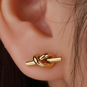 Polished gold knot stud earrings for women featuring a minimalist twisted metal design