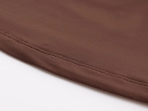 Detail of high-elasticity dark brown fabric with precise double-needle stitching and texture