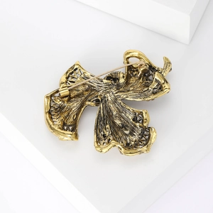 Macro detail of antique gold metal brooch back with safety pin and texture
