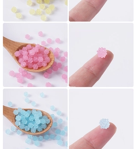 Primer plano de dijes de resina con forma de estrella colorida en cuchara para manualidades