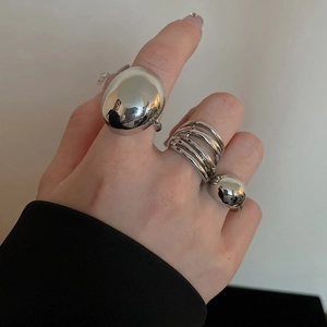 Detailed view of irregular polished silver rings set including large egg-shaped and layered designs