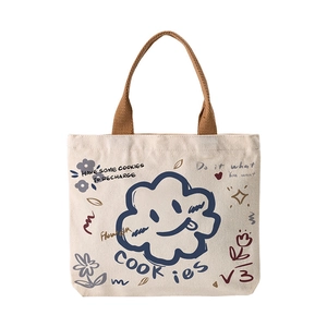 Minimalist cream canvas tote bag with brown woven handles and graffiti face prints