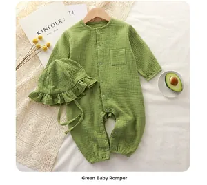 Detailed flat lay of green cotton gauze baby romper with matching ruffled bonnet hat
