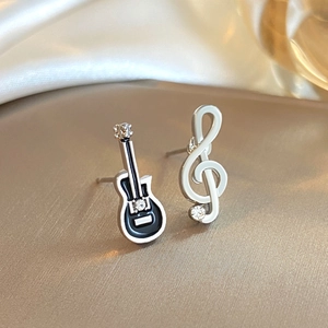 Orecchini musicali asimmetrici con chitarra e chiave di violino su sfondo satin