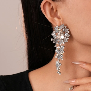 Luxurious silver tassel earrings with sparkling teardrop crystals on model