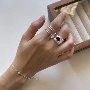 Detail of 925 sterling silver ring with oval blue gemstone and spiral textured band