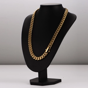 Polished gold stainless steel Cuban link necklace displayed on black neck mannequin
