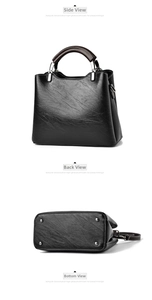 Detail view of black leather handbag featuring silver protective studs on the bottom base