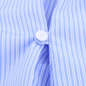 Dettaglio ravvicinato della camicia a maniche lunghe a righe bianche e blu con bottoni