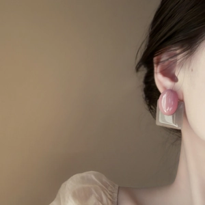 Modern pink and gray geometric resin drop earrings worn by a model in a profile view