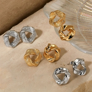 Minimalist geometric twisted earrings in polished gold and matte hammered silver finishes