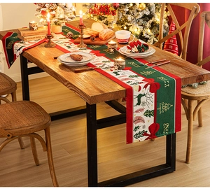 Close-up of linen Christmas table runner featuring reindeer, trees and festive patterns