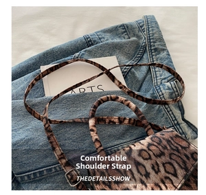 Close-up of leopard print handbag showing stitch details and adjustable metal buckle
