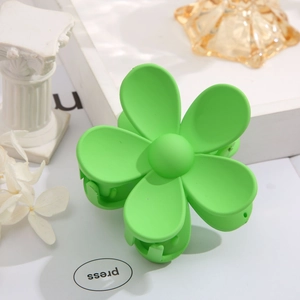 Detail of green matte flower hair claw clip on aesthetic white decorative background