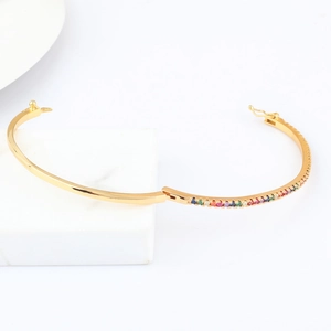 Detailed macro view of 18k gold plated oval bangle featuring rainbow zircon stones