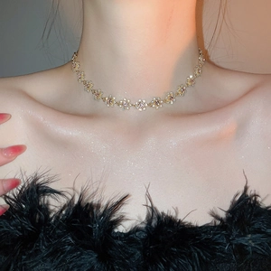 Close-up of sparkling flower pendant necklace with rhinestones on female model