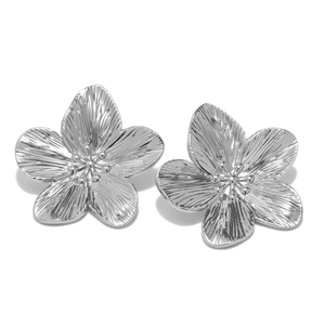 Elegant silver flower stud earrings with textured petals and a metallic finish on white