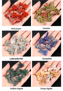 Macro shot of assorted natural crystal palm tree pendants held in hand with black background