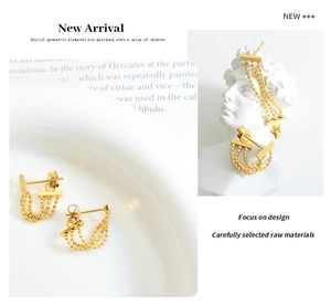 Detail of 18k gold triple layered bead chain tassel earrings displayed on a white statue