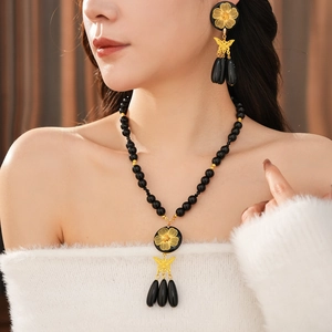 Detail of vintage beaded flower necklace and earrings set with black teardrop tassels