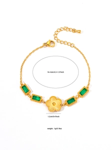 Detailed view of a gold chain bracelet with green zircons and a central sunflower charm