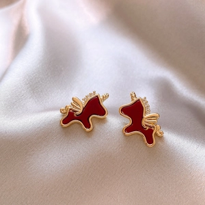 Gros plan détaillé de boucles d'oreilles licorne rouge foncé avec placage or et diamants