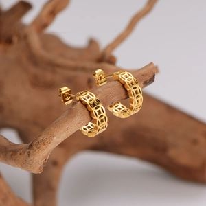 Golden hollowed coin earrings with vintage oriental pattern on a rustic wooden stand