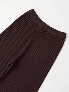 Dettaglio dei pantaloni in maglia marrone scuro con trama a costine ed elastico in vita