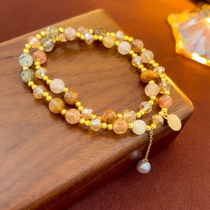 Detail of 2-piece vintage natural stone bracelet with gold logo plate and pearl charm