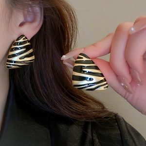 Boucles d'oreilles triangulaires vintage avec motif zébré noir et doré sur le lobe