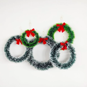 Detailed view of 5-piece multi-colored Christmas wreaths with festive red bows on white wall