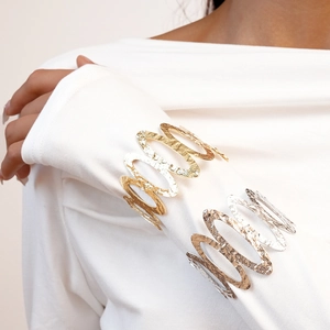 Close-up of a gold and silver hammered open cuff bracelet with wavy hollow design