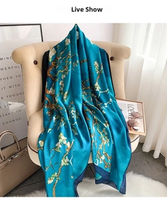 Close-up of royal blue silk scarf with white almond blossom print draped on a chair
