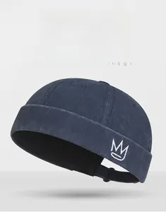 Detail of navy blue cotton docker hat with side white crown embroidery and folded brim