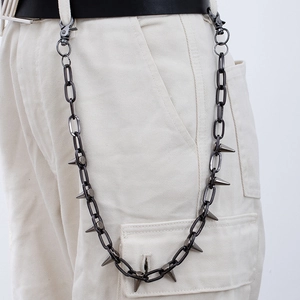Detail of punk style gunmetal trouser chain with sharp metal spikes on white pants