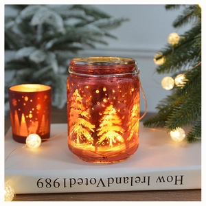 Detail of red frosted glass Christmas candle holder with warm lit tree pattern