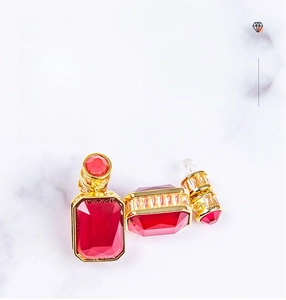 Macro detail of luxury geometric earrings with large red gemstone in gold setting