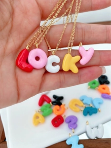 Detailansicht bunter 3D-Resin-Buchstabenanhänger, die das Wort LOCKY auf Ketten bilden