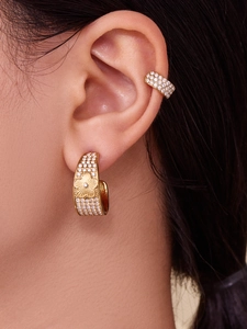 Close-up of 18k gold plated C-shaped hoop earring with zircon floral relief details
