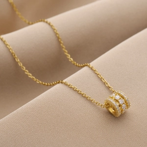 Collier minimaliste en acier titane doré avec pendentif cylindre serti de zircons