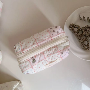 Detailed close-up of quilted floral cotton makeup bag with a cute rabbit illustration