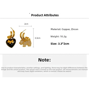Detail of asymmetrical gold earrings featuring a black heart dog and zircon elephant