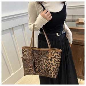 Lifestyle shot of large leopard print tote bag and mini pouch with brown leather handles