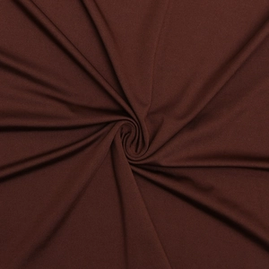 Detail view of dark brown knitted fabric with elegant swirl pleats and smooth texture