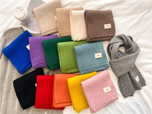Flat lay of soft knit winter scarves in a variety of vibrant candy colors