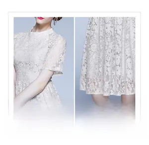 Détails de la dentelle florale au crochet sur une robe blanche élégante et ajustée