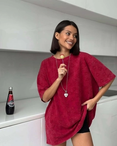Détail du t-shirt rouge oversize avec texture cœur embossée et collier cœur argenté