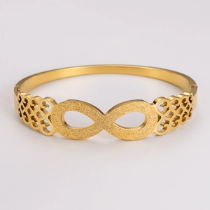 Macro detail of golden infinity bracelet featuring frosted texture and hollow patterns